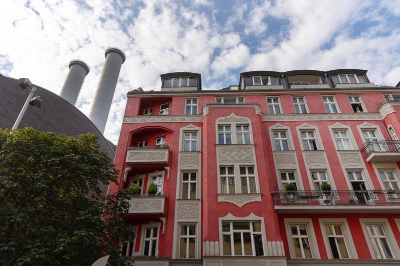 Ống khói của một nhà máy cung cấp nhiệt sưởi nằm sau một toà nhà chung cư ở Berline, Đức hôm 09/08/2022. Ảnh Bloomberg.