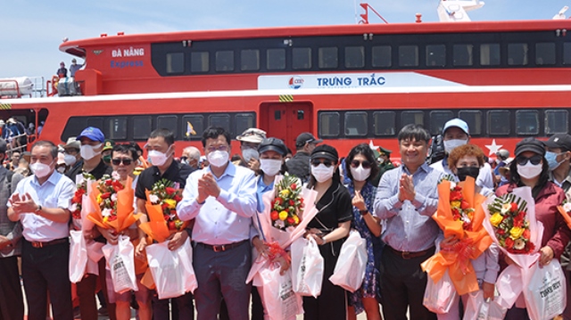 Phó Chủ tịch UBND thành phố Trần Phước Sơn tặng hoa và chụp ảnh lưu niệm cùng các hành khách đầu tiên trên chuyến tàu Đà Nẵng - Lý Sơn.