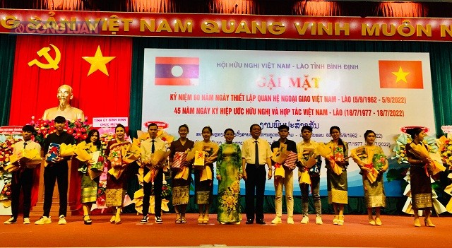 Các đồng chí Hồ Quốc Dũng và Nguyễn Thị Phong Vũ (thứ 6 và 7 từ phải qua) trao tặng 12 suất học bổng cho sinh viên Lào.