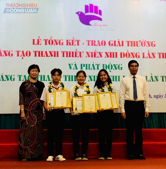 Ông Lâm Hải Giang và bà Nguyễn Thị Thanh Bình (bìa phải và bìa trái) trao 02 giải Nhất cho các tác giả.