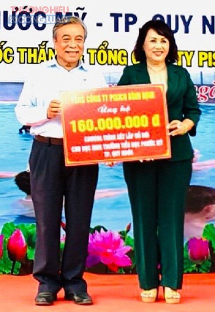 B&agrave; Đồng Thị &Aacute;nh (b&ecirc;n phải) trao tiền hỗ trợ x&acirc;y dựng hồ bơi cho đại diện l&atilde;nh dạo Hội Bảo trợ bệnh nh&acirc;n ngh&egrave;o tỉnh B&igrave;nh Định.