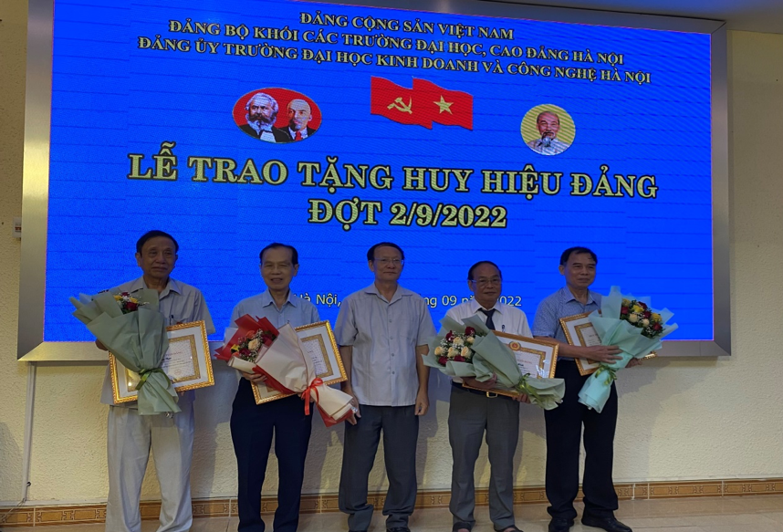 Đồng chí Nguyễn Công Nghiệp Bí thư Đảng uỷ trao tặng huy hiệu Đảng và hoa cho các đồng chí nhận huy hiệu Đảng