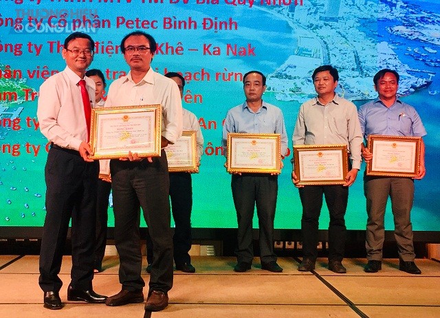 Ông Nguyễn Tự Công Hoàng (hàng đầu, bên trái) trao tặng Bằng khen của UBND tỉnh Bình Định cho các tổ chức, cá nhân.