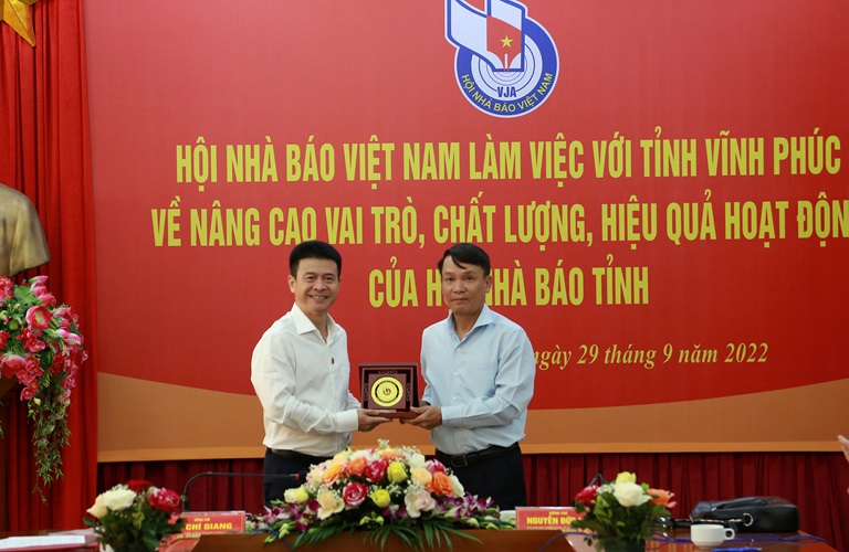 Phó chủ tịch Thường trực Hội nhà báo Việt Nam Nguyễn Đức Lợi( bên phải) trao kỷ niệm chương cho phó chủ tịch UBND tỉnh Vĩnh Phúc Vũ Chí Giang