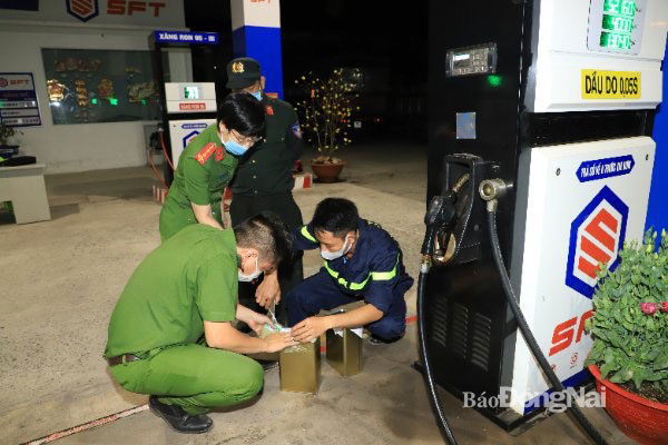 Lực lượng công an lấy mẫu xăng để đi giám định trong quá trình điều tra vụ án buôn lậu xăng dầu tại Đồng Nai