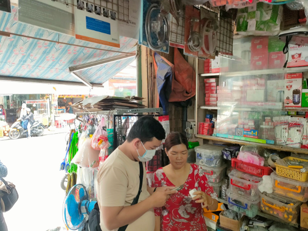 Người dân mua hàng được chủ cửa hàng tại Bình Thạnh hướng dẫn sử dụng QR code Điện Quang