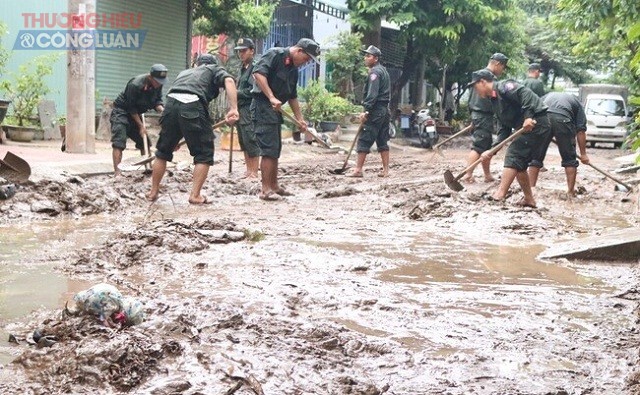 Lực lượng Cảnh s&aacute;t cơ động, Bộ C&ocirc;ng an tham gia dọn vệ sinh khu vực bị ngập ở phường Ghềnh R&aacute;ng, TP Quy Nhơn.