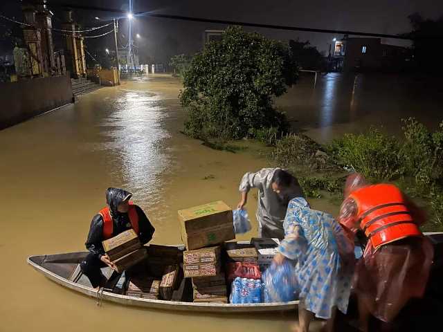 Lực lượng chức hỗ trợ đưa quà đến người dân vùng ngập nước