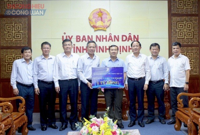 Ông Tô Dũng Thái (thứ 04 từ trái qua) trao bảng tượng trưng 01 tỷ đồng cho ông Phạm Văn Nam, hỗ trợ Quỹ “Vì người nghèo” tỉnh Bình Định năm 2022.