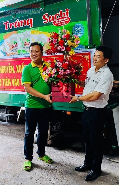Lãnh đạo UBND thị xã Hoài Nhơn (bên phải ) tặng hoa chúc mừng lãnh đạo Công ty TNHH Sachi Nguyễn lần đầu tiên xuất khẩu bánh tráng sang thị trường Mỹ.
