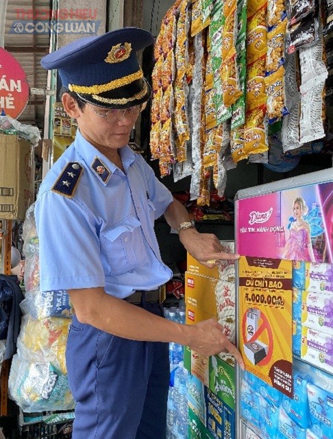 Nh&acirc;n vi&ecirc;n Đội QLTT số 05, Cục QLTT B&igrave;nh Định đang thực hiện d&aacute;n &aacute;p phich cảnh b&aacute;o h&agrave;nh vi vi phạm bu&ocirc;n b&aacute;n, vận chuyển, t&agrave;ng trữ thuốc l&aacute; điếu nhập lậu.