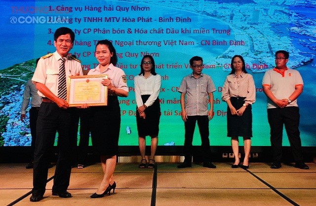 Ông Nguyễn Đẩu (hàng đầu, bên trái) trao tặng Giấy khen của Tổng cục Thuế và Cục Thuế Bình Định cho các tổ chức, cá nhân có thành tích chấp hành tốt chính sách pháp luật thuế.