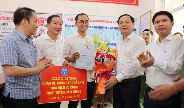Phó Tổng Giám đốc BHXH Việt Nam Chu Mạnh Sinh trao tấm thẻ BHYT đầu tiên trên toàn quốc cho bé gái dưới 6 tuổi được thực hiện qua Dịch vụ công liên thông