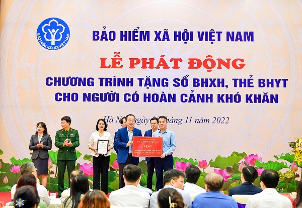 Phó Tổng Giám đốc Vietcombank Nguyễn Việt Cường (hàng đầu, bên trái) trao biểu trưng tặng 1.000 sổ BHXH, 9.968 thẻ BHYT với tổng trị giá 5 tỷ đồng cho đại diện BHXH Việt Nam