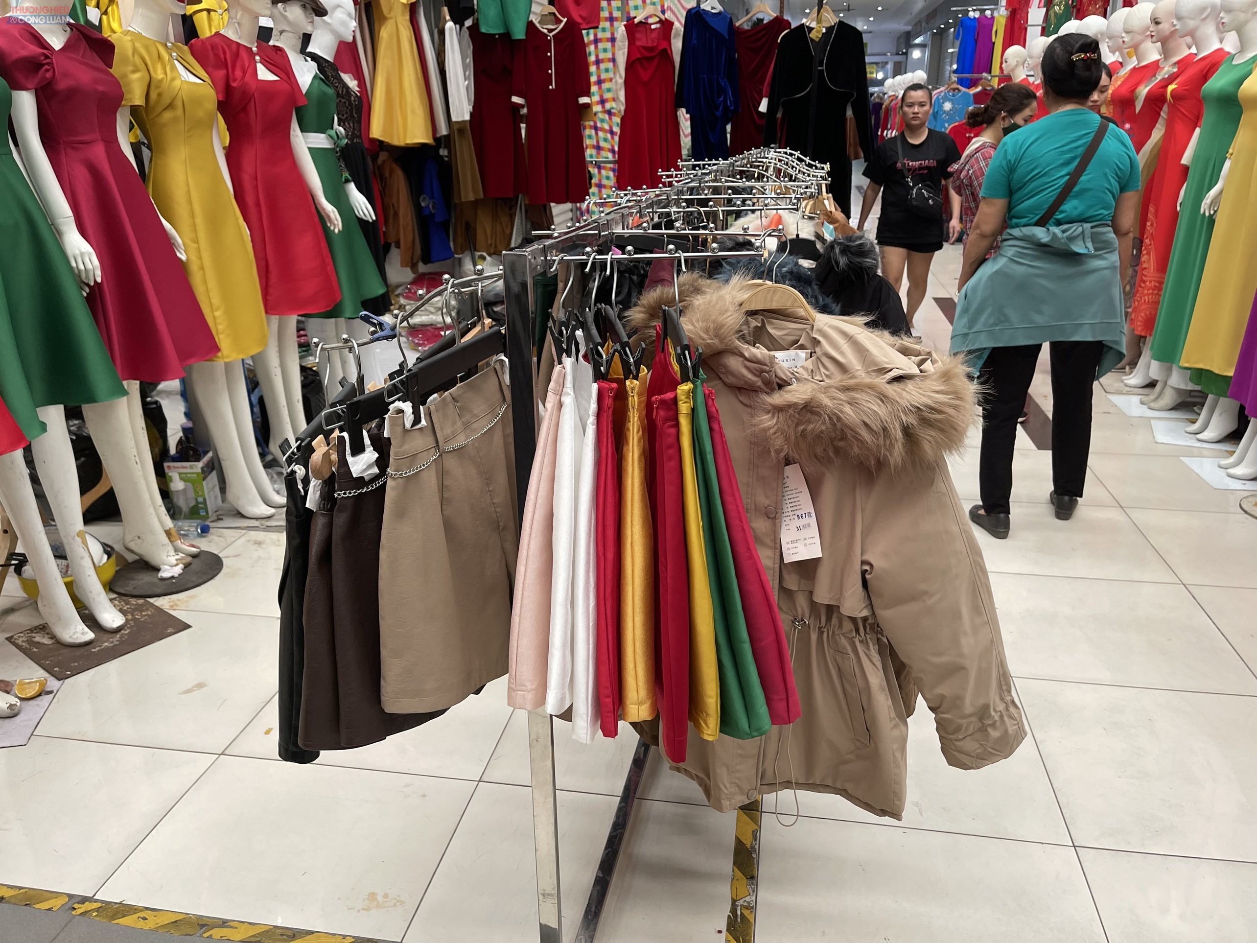 Quần áo, hàng hóa được bày bàn giữa đường đi của TTTM