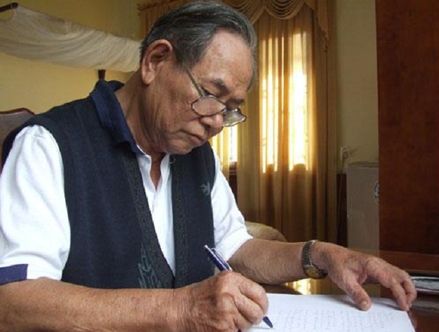 Nhà văn Nguyễn Quang Hà bên bàn viết ở tư gia.