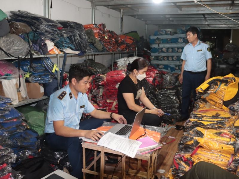 Lực lượng chức năng tỉnh Thái Bình làm việc với chủ kho hàng trong vụ quần áo giả mạo nhãn hiệu THE NORTH FACE và hình đang được bảo hộ tại Việt Nam.