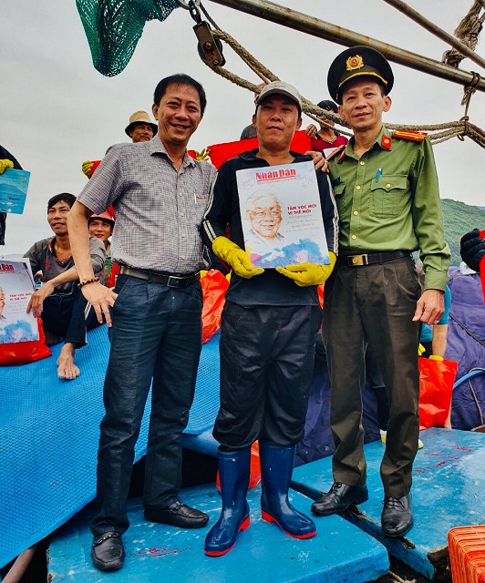 Ông Đào Xuân Thiện (bìa trái) và đại diện lãnh đạo Đội Quản ly Nông – Lâm – Ngư nghiệp (Công an Bình Định) trao tặng Báo Nhân Dân Xuân Qúy Mão 2023.