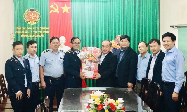 Ông Trần Hoàng Tuấn (thứ 05 từ phải qua) trao tặng quà Tết cho lãnh đạo Cục QLTT Quảng Ngãi.