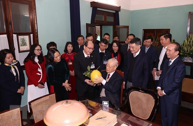 Cán bộ, nhân viên Khu di tích Chủ tịch Hồ Chí Minh kính tặng Tổng Bí thư Nguyễn Phú Trọng trái bưới trong vườn Bác. Ảnh TTXVN