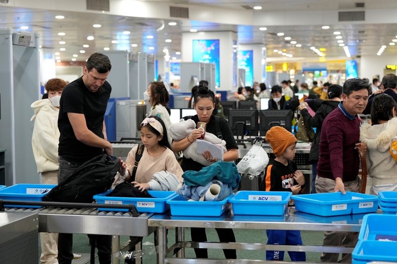 Hành khách kiểm tra an ninh hàng không tại sân bay Nội Bài sáng 29-1.