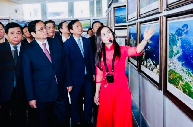 Thủ tướng Chính phủ Phạm Minh Chính (hàng trước, thứ 2 từ trái qua) nghe thuyết minh, giới thiệu về các tác phẩm ảnh nghệ thuật.