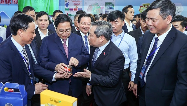 Thủ tướng Chính phủ Phạm Minh Chính dẫn đầu đến tham quan khu trưng bày sản phẩm nông sản đặc trưng của các địa phương vùng Bắc Trung bộ và Duyên hải Trung bộ