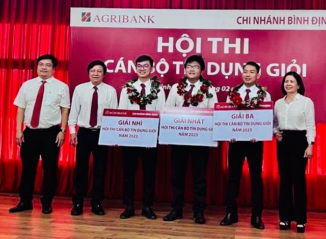 Ông Nguyễn Xuân Hùng (thứ 02 từ trái qua) và các thành viên Ban giám dốc Chi nhánh Agribank Bình Định trao các giải Nhất, Nhì, Ba cho các cán bộ tín dụng.