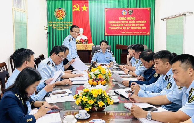 Ông Võ Minh Tâm (đứng trong cùng, bên trái) báo cáo với Đoàn công tác Tổng cục QLTT về tình hình hoạt động của Cục QLTT tỉnh Quảng Ngãi. Ảnh: T-Thuỷ