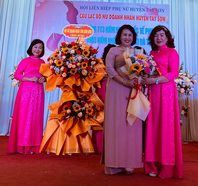 Bà Đồng Thị Ánh (thứ 02 từ phải qua) tặng hoa chúc mừng CLB Nữ doanh nhân huyện Tây Sơn.
