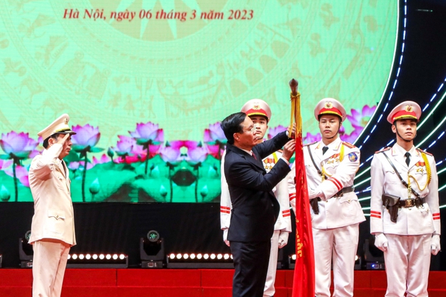 Chủ tịch nước Võ Văn Thưởng gắn Huân chương Bảo vệ Tổ quốc hạng Nhất lên Cờ truyền thống của lực lượng Xây dựng lực lượng CAND - Ảnh: VGP/Nhật Nam