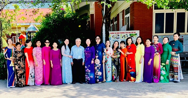 &Ocirc;ng Nguyễn Tấn Hiểu (thứ 08 từ tr&aacute;i qua) chụp ảnh lưu niệm c&ugrave;ng c&aacute;c mẹ, d&igrave;, c&ocirc; bảo mẫu với trang phục &aacute;o d&agrave;i truyền thống.