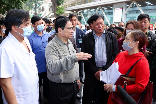 Thủ tướng thăm hỏi người nhà bệnh nhân về tình hình đáp ứng vật tư y tế và thuốc men tại bệnh viện Bạch Mai - Ảnh: VGP/Nhật Bắc