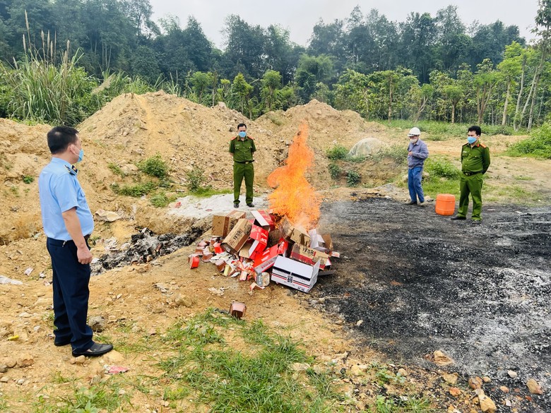 Lực lượng chức năng tổ chức tiêu hủy 94 thùng bánh kẹo, phở trộn không có nguồn gốc xuất xứ bị thu giữ. Ảnh: Công an tỉnh Lào Cai