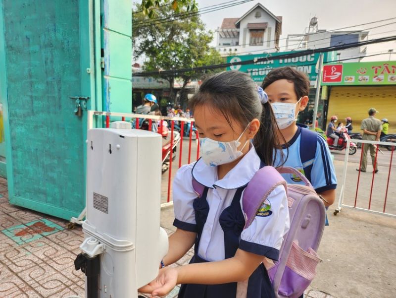 Học sinh Trường Tiểu học Lê Văn Thọ, quận Gò Vấp đeo khẩu trang, rửa tay trước khi vào trường