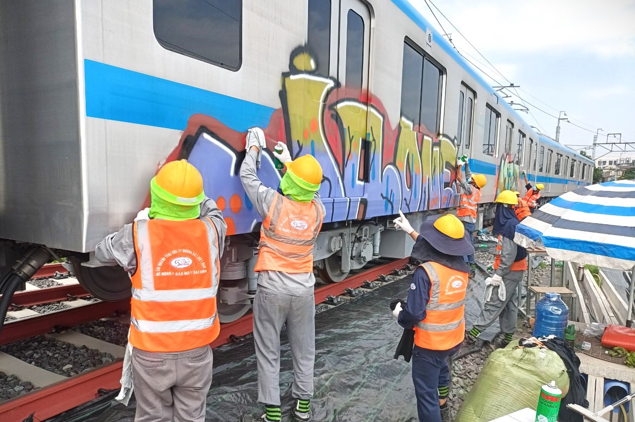 Công nhân tẩy rửa toa tàu Metro số 1 bị vẽ bậy. Ảnh: Ban Quản lý đường sắt đô thị TP Hồ Chí Minh