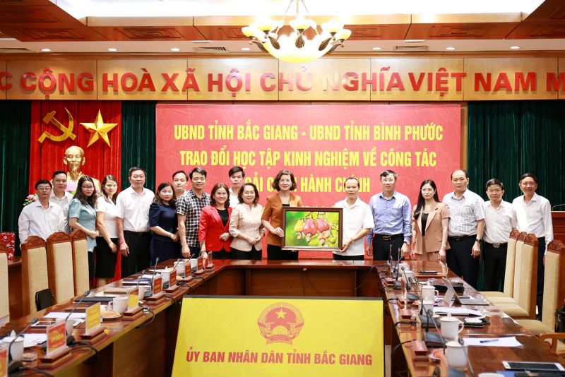 Bà Trần Tuyết Minh - Phó Chủ tịch UBND tỉnh Bình Phước trao quà lưu niệm tặng tỉnh Bắc Giang.