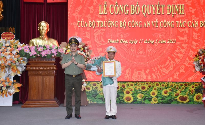 Thiếu tướng Trần Phú Hà, Giám đốc Công an tỉnh Thanh Hóa thừa ủy quyền của Lãnh đạo Bộ Công an trao Quyết định và tặng hoa chúc mừng Thượng tá Lê Ngọc Anh