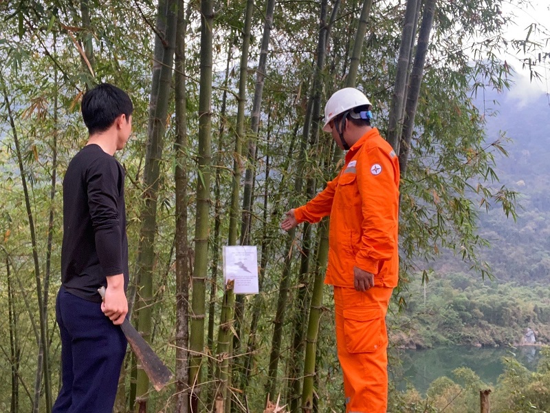 Công nhân Điện lực trực thuộc Công ty Điện lực Thanh Hóa tuyên truyền đến người dân về việc chặt tỉa cây trồng nằm trong phạm vi có nguy cơ gây mất an toàn hành lang lưới điện