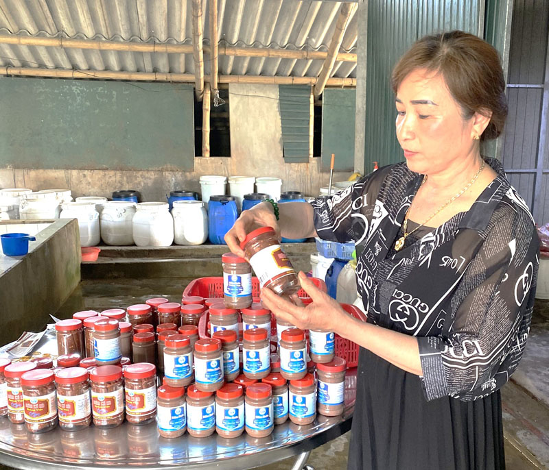Chị Nguyễn Thị Thiếc giới thiệu 2 sản phẩm OCOP đạt hạng sản phẩm 3 sao là mắm ruốc, mắm cá rò - Ảnh: NVCC