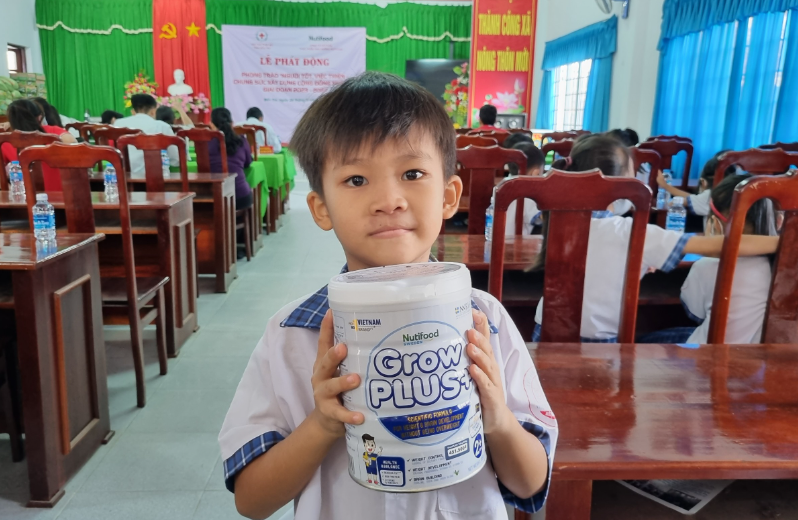 Bé Nguyễn Hoàng Thanh vui mừng khoe phần sữa nhận được từ Nutifood