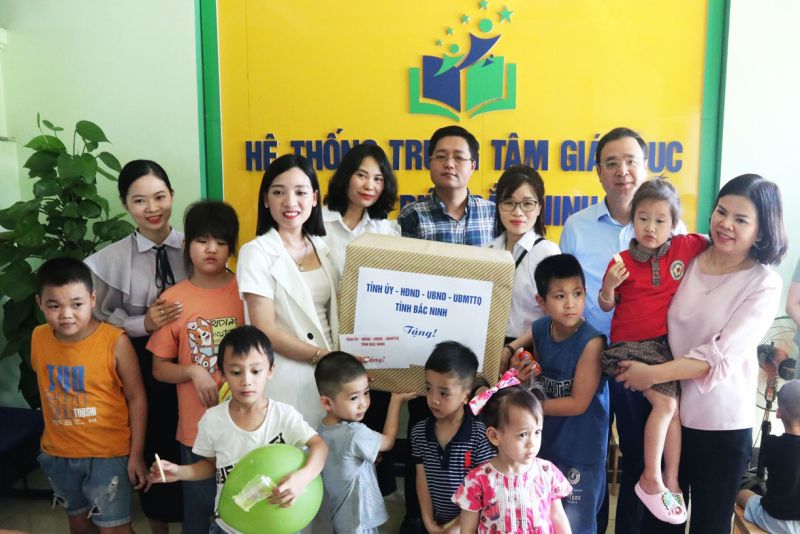 Chủ tịch UBND tỉnh Nguyễn Hương Giang (bế cháu bé mặc áo đỏ) và tặng quà cho Trung tâm hỗ trợ phát triển giáo dục hòa nhập Bắc Ninh