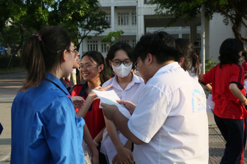 Các bạn thanh niên tình nguyện là học sinh trường THPT Chuyên Hạ Long cùng các sĩ tử nhận định về đề thi và thảo luận về bài làm. (Ảnh Báo Quảng Ninh)