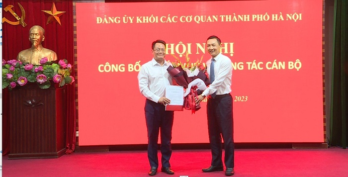Bí thư Đảng ủy Khối các cơ quan thành phố Hà Nội Doãn Trung Tuấn trao quyết định và tặng hoa chúc mừng đồng chí Nguyễn Việt Hùng