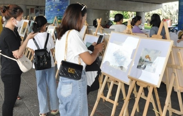 Người dân và khách thập phương lưu lại những bức tranh tại cuộc triển lãm.