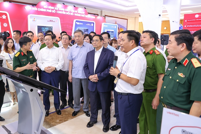 Thủ tướng Phạm Minh Chính và các đồng chí lãnh đạo tham quan triển lãm mô hình, sản phẩm ứng dụng triển khai Đề án 06 - Ảnh: VGP/Nhật Bắc
