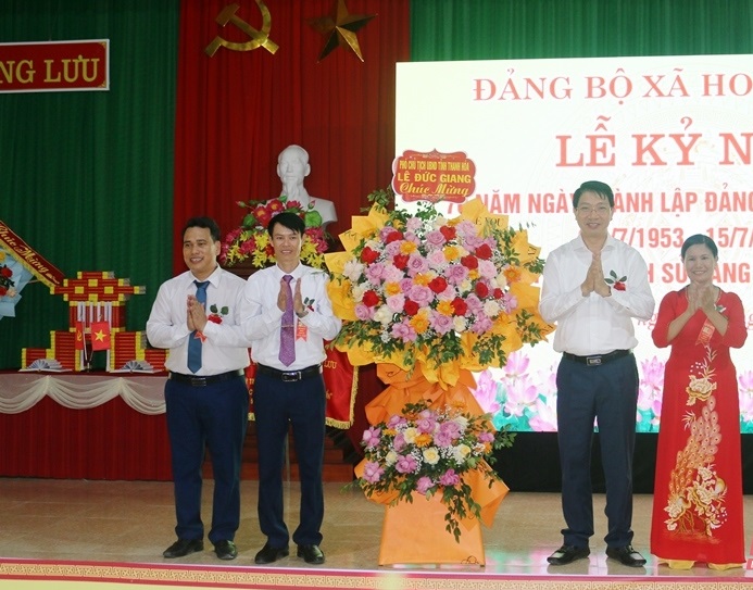 Ông Lê Đức Giang, Phó Chủ tịch UBND tỉnh tặng hoa chúc mừng Đảng bộ, Nhân dân xã Hoằng Lưu.