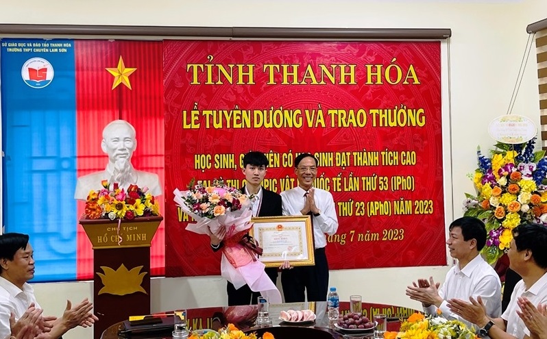 Phó Chủ tịch UBND tỉnh Đầu Thanh Tùng tặng hoa và Bằng khen, phần thưởng của Chủ tịch UBND tỉnh cho em Lê Viết Hoàng Anh.