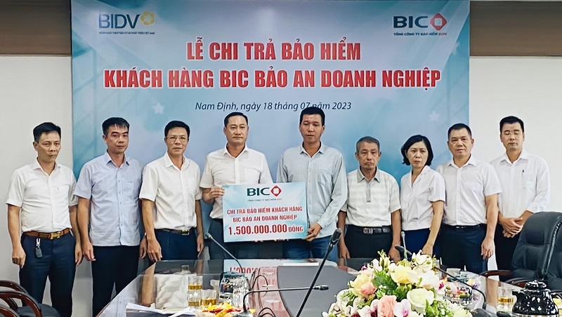 Đại diện BIC và BIDV Thành Nam trao số tiền bảo hiểm cho đại diện gia đình người được bảo hiểm, bà T.T.V