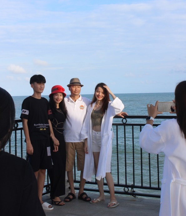 Anh Phạm Văn Khởi chụp hình trên cầu ngắm biển cùng gia đình